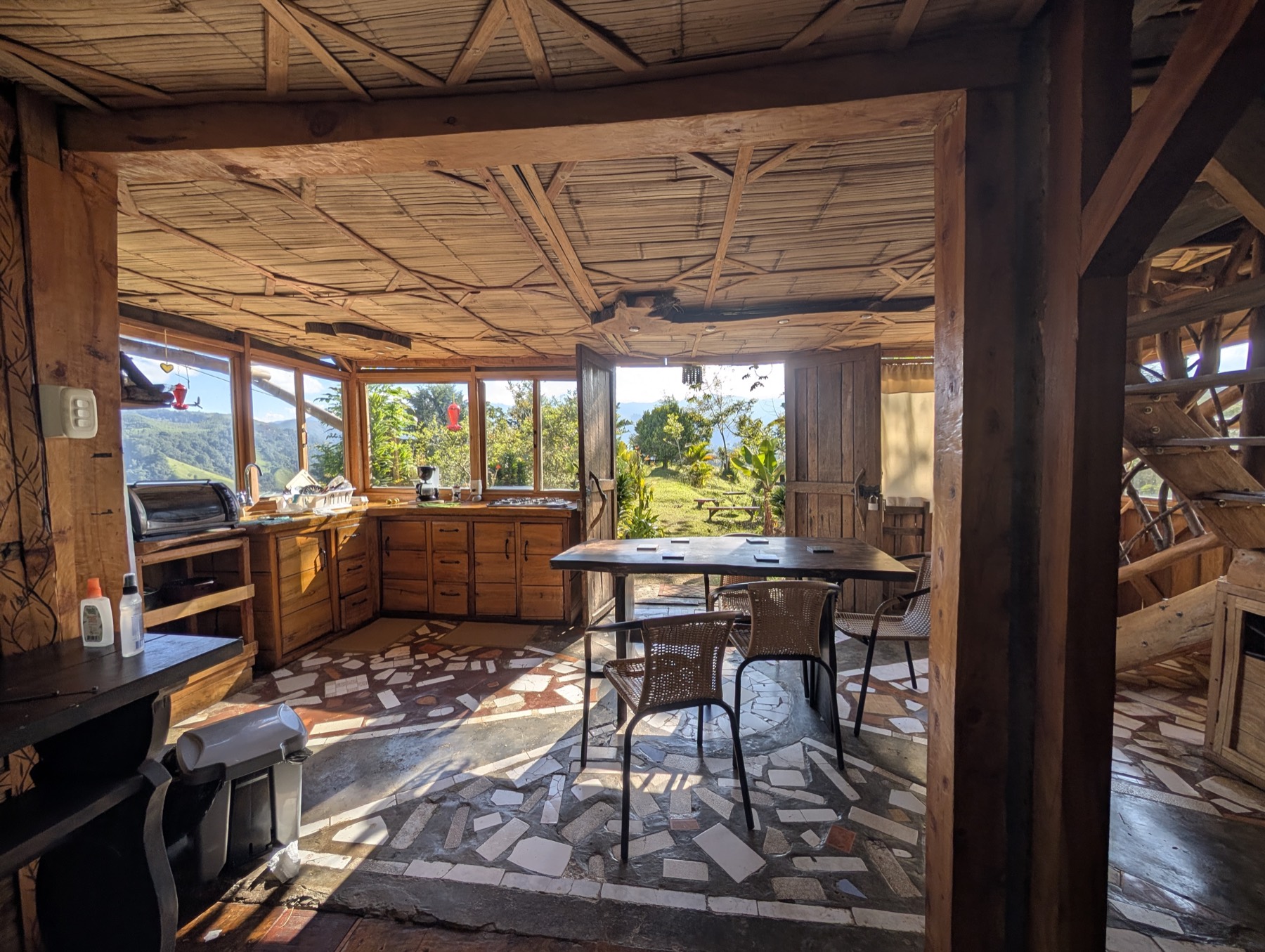 Comedor rústico con piso de mosaico y vista al valle